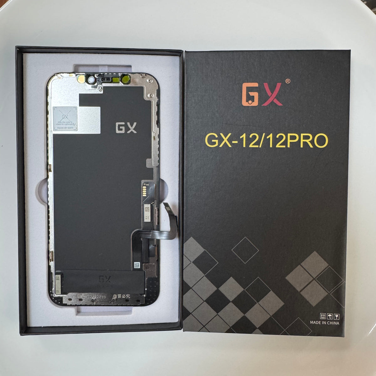 Hard OLED screen for iPhone 12 and 12 Pro in its tray, beside its labelled box